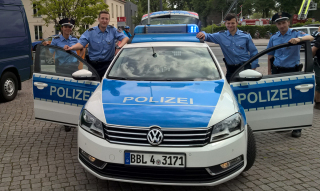 Anwärter posieren am Streifenwagen VW Passat