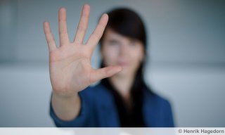 Frau zeigt mit ihrer rechten Hand das Stopp-Zeichen