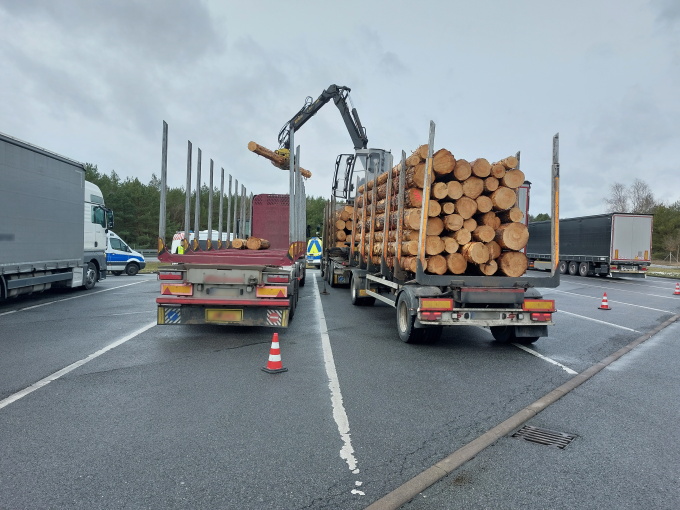 Überladener Holztransporter beim Umladen